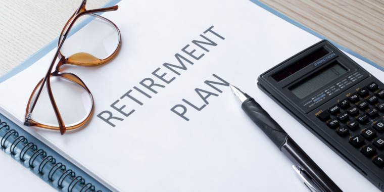 Retirement plan document on a desk with eyeglasses, a calculator, and a black pen.
